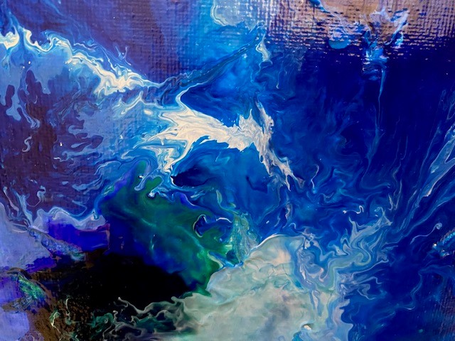 An abstract acrylic pouring painting of blue, white and black swirls.